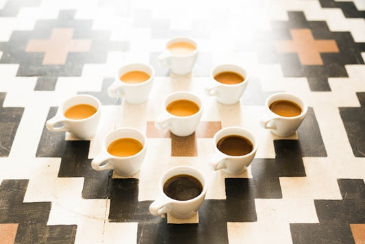 different shades of coffee in white coffee mugs arranged on the patterned floor